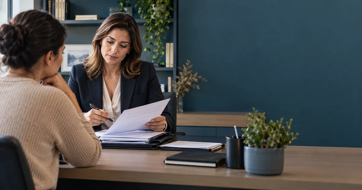 Advogada confere documentos de cliente para ação de pensão