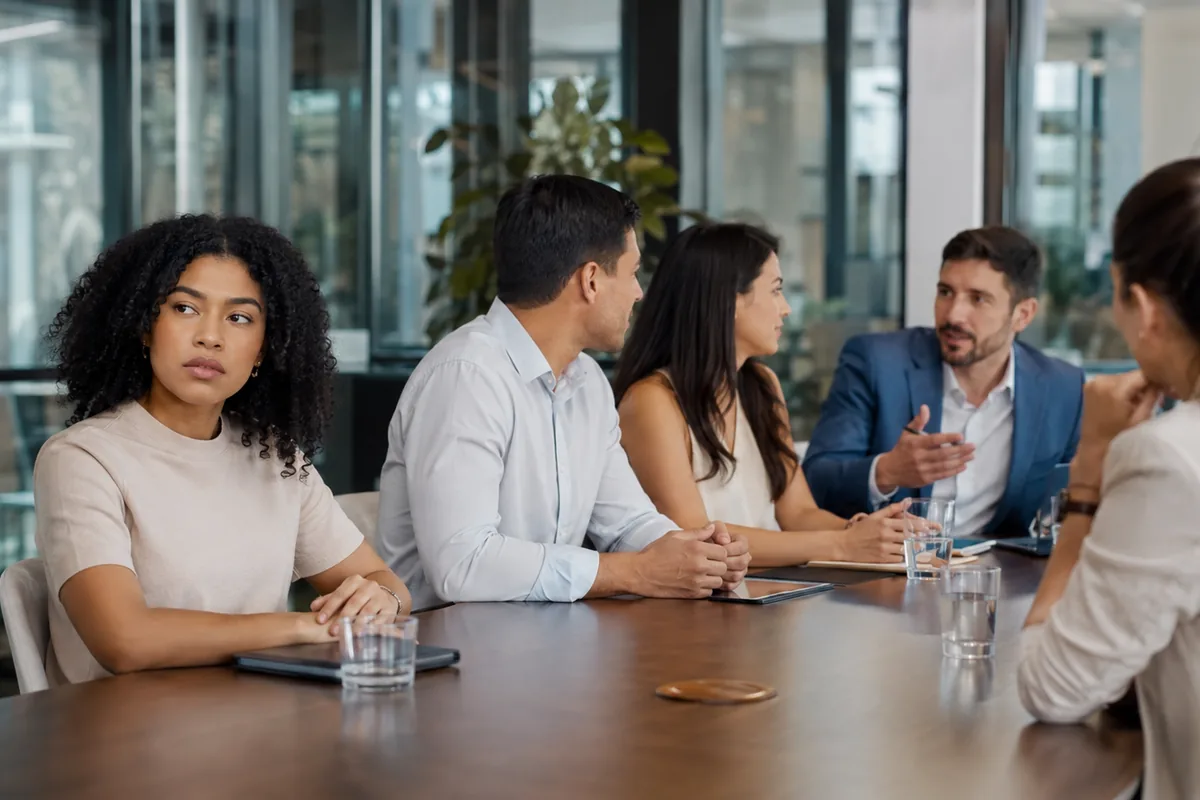 Profissional isolada durante reunião de equipe no trabalho