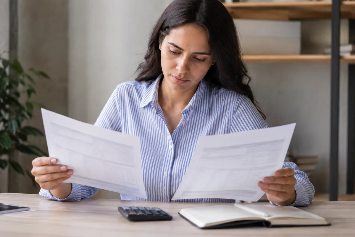Profissional compara recibos de salário de meses diferentes