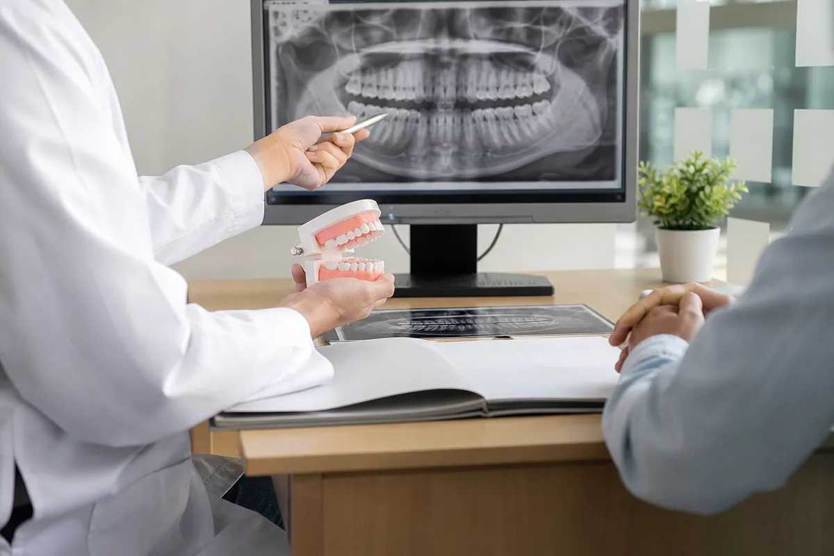 Dentista avaliando radiografia panorâmica e modelo dental