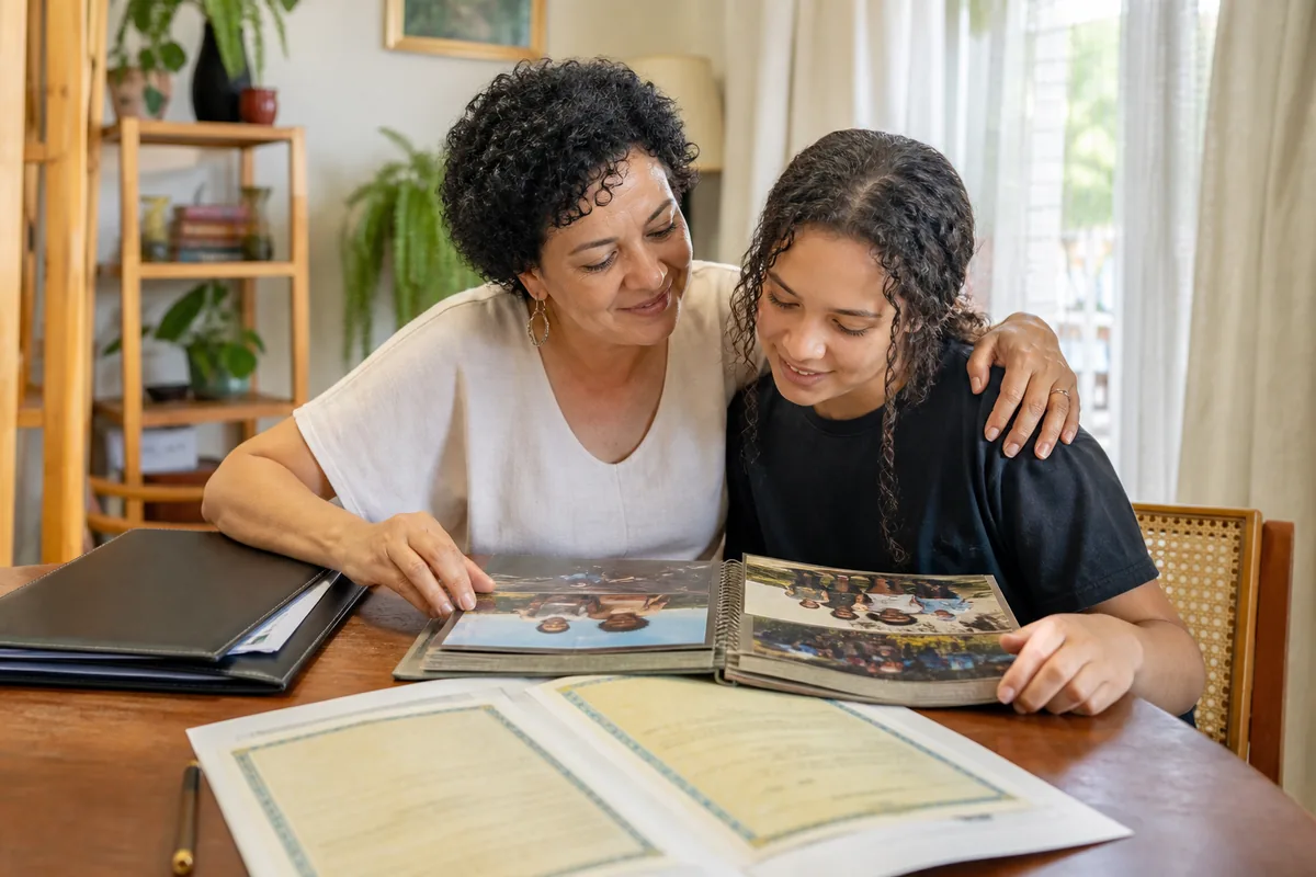 Mãe e adolescente revisam álbum e documentos de vínculo socioafetivo