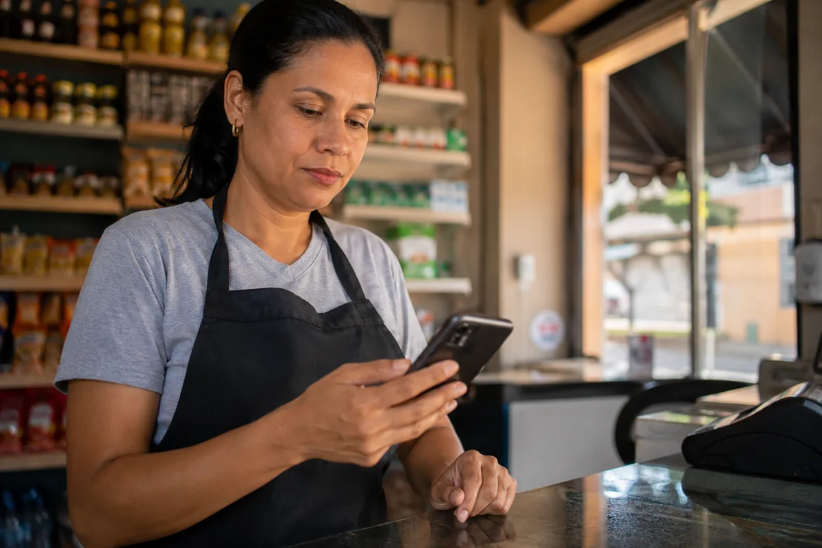 Trabalhadora confere informações de emprego no celular