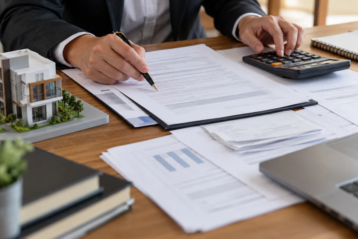 Documentos, calculadora e maquete usados para conferir valores do distrato
