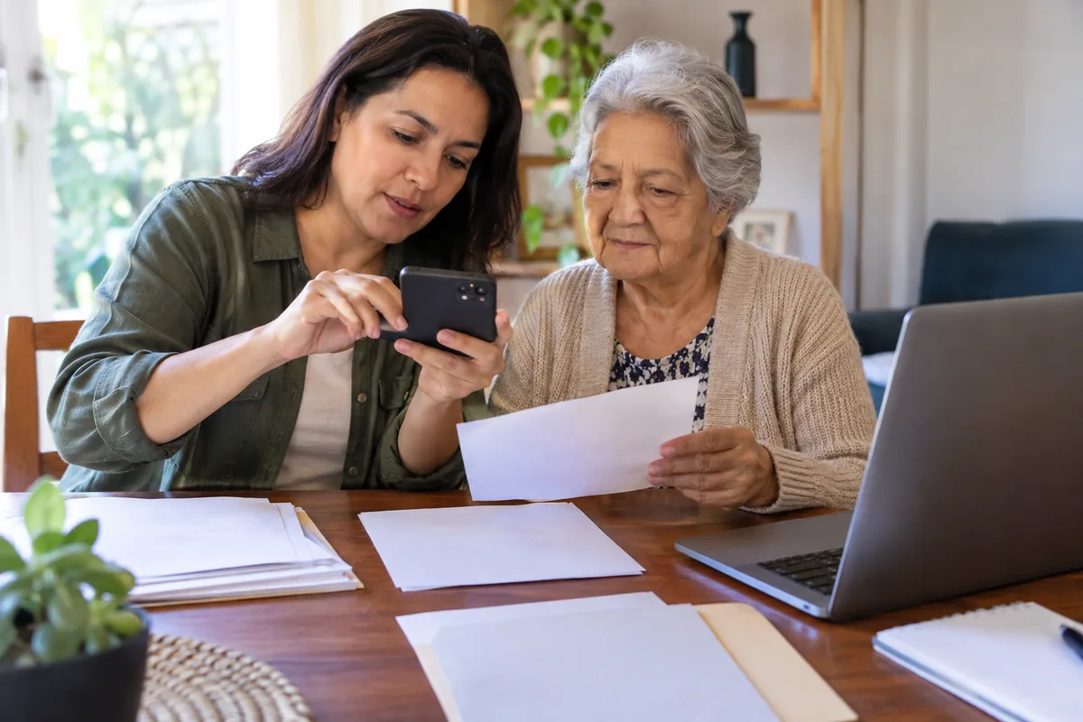Familiar ajuda idosa a digitalizar documentos para pedido de BPC
